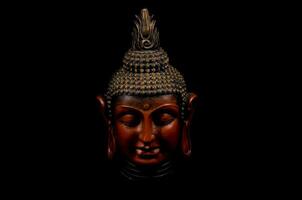 ein Buddha Statue ist gezeigt gegen ein schwarz Hintergrund foto