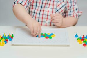 das Baby Theaterstücke mit ein Mosaik Sitzung beim ein Tabelle foto