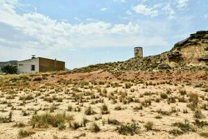 ein Haus im das Mitte von ein Wüste mit ein Turm foto