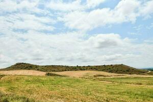 ein Feld mit ein Hügel im das Hintergrund foto