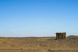 ein klein Hütte im das Wüste mit ein Blau Himmel foto