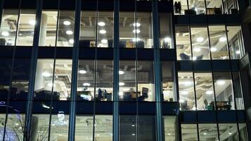 Muster von Büro Gebäude Fenster beleuchtet beim Nacht. Glas die Architektur , Unternehmen Gebäude beim Nacht - - Geschäft Konzept. foto