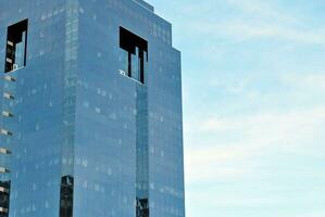 strukturell Glas Mauer reflektieren Blau Himmel. abstrakt modern die Architektur Fragment foto