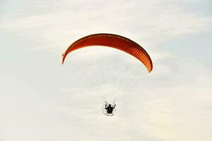 ein Person ist Gleitschirmfliegen im das Himmel foto