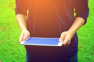 ein Person halten ein Tablette Computer mit ein Blau Bildschirm foto