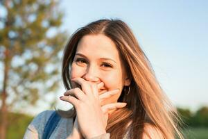 überrascht jung Frau mit Hände Über ihr Mund draussen foto