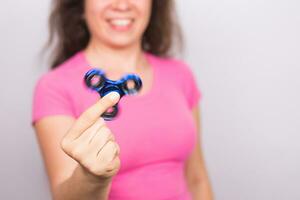 jung Frau spielen mit ein zappeln Spinner schließen hoch, Fokus auf Spinner. foto