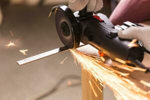 Arbeiter mit Winkel Schleifer im Fabrik und werfen Funken. foto