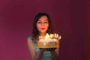 schön kaukasisch Mädchen weht Kerzen auf ihr Kuchen. Geburtstag, Party und Feier Konzept foto