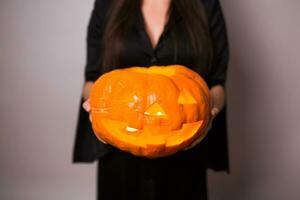 Jack Ö Laterne Halloween Kürbis grinsend im das die meisten böse Mode im Frau Hände. foto