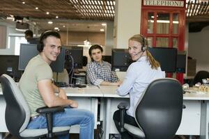 ein Frau im ein Headset reden zu ein Mann beim ein Schreibtisch foto