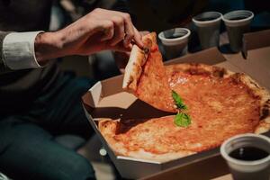 ein Mann ist Schneiden ein Pizza in Stücke foto