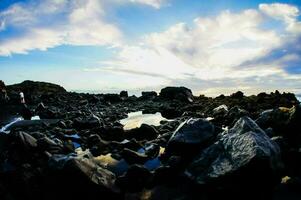 ein Aussicht von das Felsen und Wasser beim das Strand foto