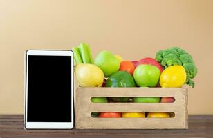 Obst und Gemüse Box und Tablette Bildschirm foto