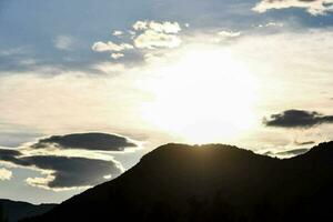 das Sonne ist Rahmen hinter ein Berg Angebot foto