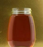 ein Krug von Honig auf ein Gold Hintergrund foto