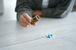 Hand Gießen aus Tabletten von ein Flasche, ein Konzept von Medikation Verwaltung foto