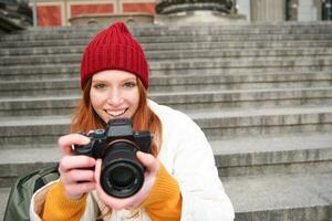 jung Student, Fotograf sitzt auf Straße Treppe und prüft ihr Schüsse auf Fachmann Kamera, nehmen Fotos draußen