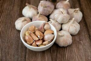 groß und klein Köpfe von Knoblauch auf ein Holz Korn Hintergrund foto