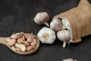 groß und klein Köpfe von Knoblauch auf ein schwarz Hintergrund. foto