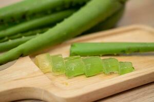 geschält Aloe vera Gel ist platziert auf ein hölzern Platte. dekoriert mit Aloe vera Blätter. foto