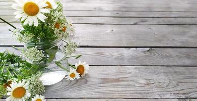 Strauß Gänseblümchen. Wildblumen Kamille stehen in einer Vase. Holzhintergrund, Ansicht von oben.