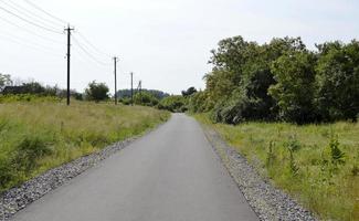 schöne leere Asphaltstraße in der Landschaft auf farbigem Hintergrund foto