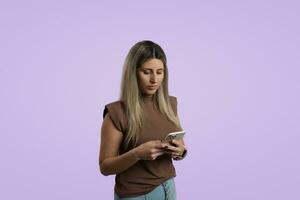 jung Erwachsene Frau halten Smartphone, Stehen im Studio mit farbig Hintergrund foto