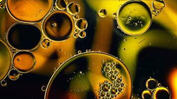 Abstraktes buntes Speiseöl lässt Blasen und Kugeln fallen, die auf der Wasseroberfläche fließen foto