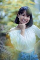 schön asiatisch Teenager zahnig lächelnd Gesicht gegen bunt verwischen Hintergrund foto