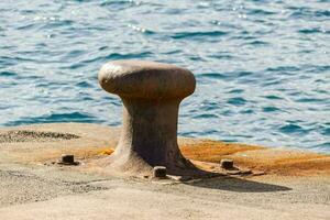 ein Metall Anker auf das Kante von ein Seebrücke foto