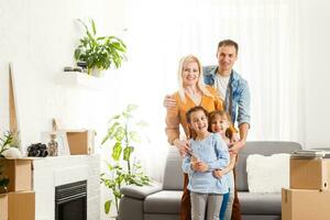 glücklich Familie mit Karton Kisten im Neu Haus beim ziehen um Tag. foto