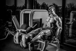 Bein Übungen - - Mann tun Bein mit Maschine im Fitnessstudio foto