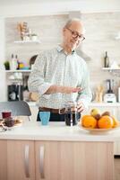 Senior Mann Herstellung Kaffee mit Französisch Drücken Sie während Frühstück im Küche. Alten Person im das Morgen genießen frisch braun Cafe Espresso Tasse Koffein von Jahrgang Becher, Filter entspannen Erfrischung foto