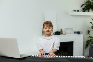 wenig Mädchen Lernen das Klavier während Quarantäne. Coronavirus Konzept. foto