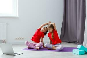 schön sportlich jung Mädchen üben Yoga zusammen beim Zuhause foto