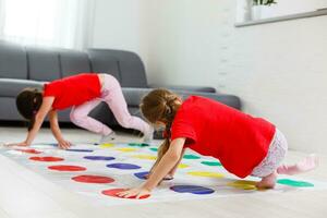 zwei glücklich Mädchen im Kinder- Kleider begeistert abspielen auf das Boden. foto