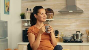 Frau Trinken heiß Kaffee zu aufwachen oben im das Morgen. Dame Freude ein Tasse von Kaffee im das Morgen. glücklich Hausfrau entspannend und Verderben Sie selber mit ein gesund Mahlzeit allein foto