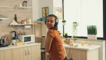 Frau voll von Glück Tanzen im das Küche beim Frühstück. energisch, positiv, Glücklich, komisch und süß Hausfrau Tanzen allein im das Haus. Unterhaltung und Freizeit allein beim Zuhause foto