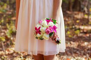 Braut in Rosa mit einem Brautstrauß aus Blumen foto