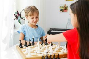 Zwei süße Kinder spielen zu Hause Schach foto