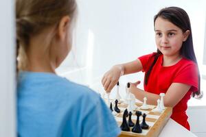 Zwei süße Kinder spielen zu Hause Schach foto