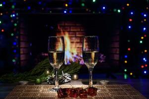 zwei Brille mit Wein auf das Tabelle gegen das Hintergrund von das Kamin. foto