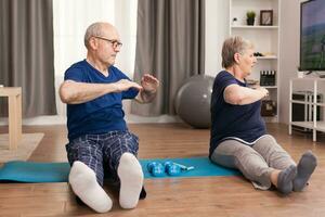 aktiv Senior Paar Dehnen ihr Körper. alt Person gesund Lebensstil Übung beim heim, trainieren und Ausbildung, Sport Aktivität beim Zuhause auf Yoga Matte. foto