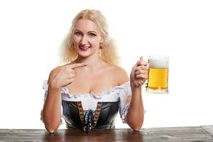 schön jung blond Mädchen im traditionell Kostüm Getränke aus von Oktoberfest Bier Stein. foto