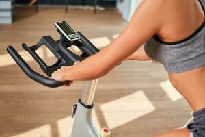 Frau Hände auf ein Bar stationär Fahrrad das Fitnessstudio foto