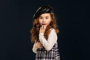 stilvoll Brünette Kind ist posieren im Studio auf ein schwarz Hintergrund. Kinder- Mode. foto