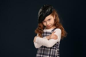 stilvoll Brünette Kind ist posieren im Studio auf ein schwarz Hintergrund. Kinder- Mode. foto