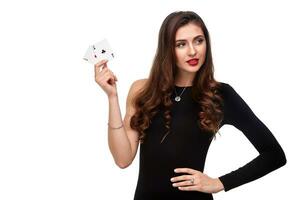 sexy lockig Haar Brünette posieren mit zwei Asse Karten im ihr Hände, Poker Konzept Isolierung auf Weiß Hintergrund foto