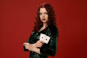 jung sexy Frau mit ein rot lockig Haar halten Asse, auf ein rot Hintergrund. Poker foto